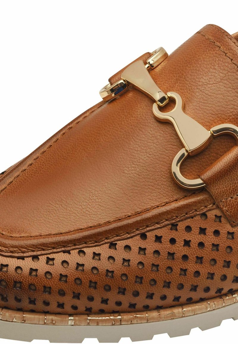 Scarpa slip-on in pelle marrone con dettagli perforati, un accento di fibbia dorata metallica e suola bianca strutturata.