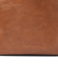Brown leather bag with a textured surface. Features embossed logo "Castelijn & Beerens" in the center. Simple, rectangular design.
