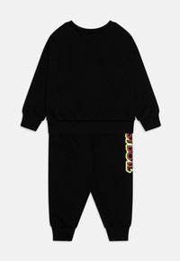 Completo due pezzi nero realizzato in tessuto morbido. Comprende una felpa a girocollo e pantaloni jogger con una grafica colorata sul lato.