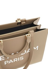 Borsa a spalla in ecopelle beige con dettagli dorati, due manici, una tasca interna con zip e testo "MADAM PARIS" in bianco sul davanti.