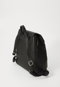 Zaino in pelle nera con una texture liscia, caratterizzato da accessori in oro, spallacci regolabili e una chiusura con zip sicura sul lato.