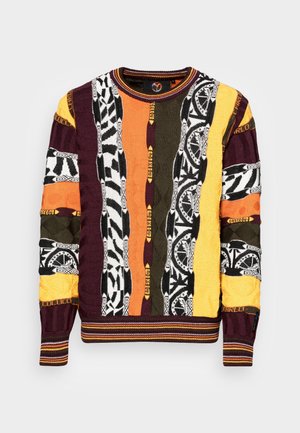 Maglione lavorato a maglia con un design patchwork composto da strisce di arancione, giallo, verde, nero e viola, arricchito da vari motivi e texture.