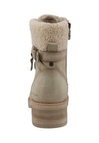 Botte en cuir beige avec un revers en fausse fourrure, détail de boucle et semelle texturée. Présente un bout rond et des coutures contrastées.