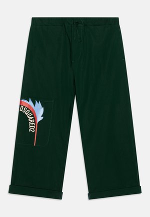 Pantalones de algodón verde con cintura elástica, que cuentan con un gran bolsillo de parche impreso a color con la marca 'DSQUARED2' y un diseño gráfico.