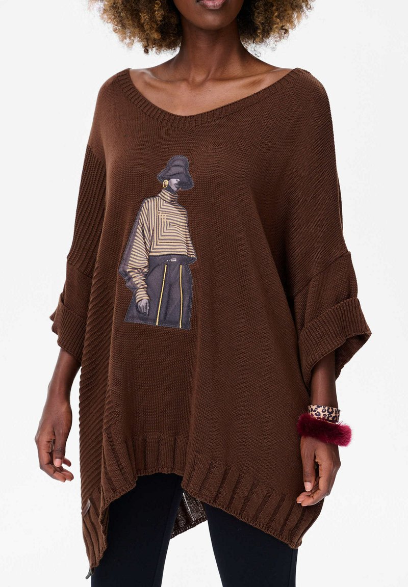 Bruine gebreide poncho met een relaxte pasvorm, met een grafisch ontwerp van een gestreepte figuur. Ribbeldetails op de mouwen en de zoom, textuurstof.