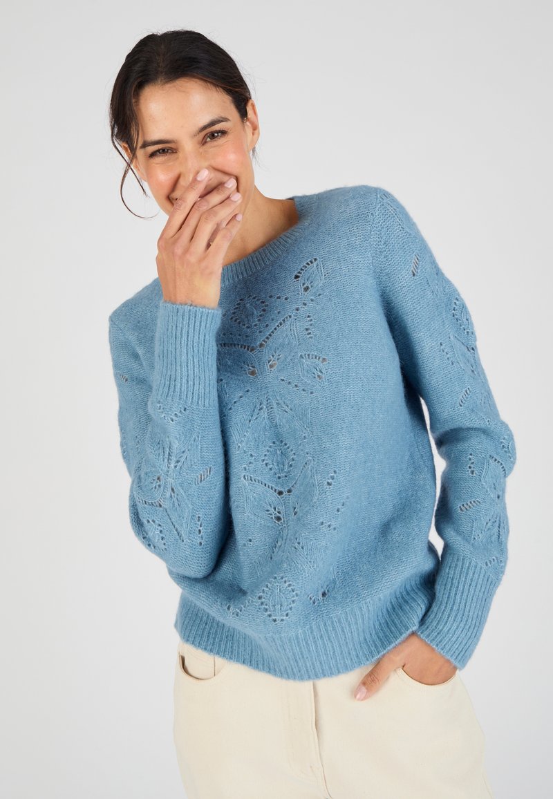 Maglione lavorato a maglia di colore azzurro chiaro con motivi in pizzo floreale, polsini e orlo a coste, colletto rotondo e tessuto morbido e testurizzato.