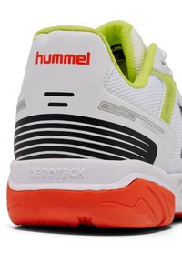 Scarpa da ginnastica bianca con dettagli neri e verde neon, dotata di una suola texturizzata, supporto per il tallone arrotondato e il marchio "Aerotech".