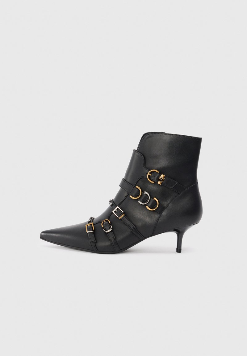Botín de cuero negro hasta el tobillo con punta afilada, que presenta acentos de metal dorado y plateado, correas ajustables y un tacón modesto.