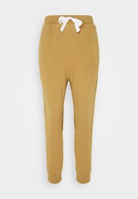 Senfgelbe Sweatpants mit weißem Kordelzug, schmalem Schnitt, elastischen Bündchen und Seitentaschen, aus weichem Stoff gefertigt.