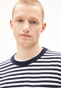 T-shirt a righe con strisce orizzontali blu navy e bianche, collo tondo e maniche corte. Il tessuto appare morbido con una finitura pulita.