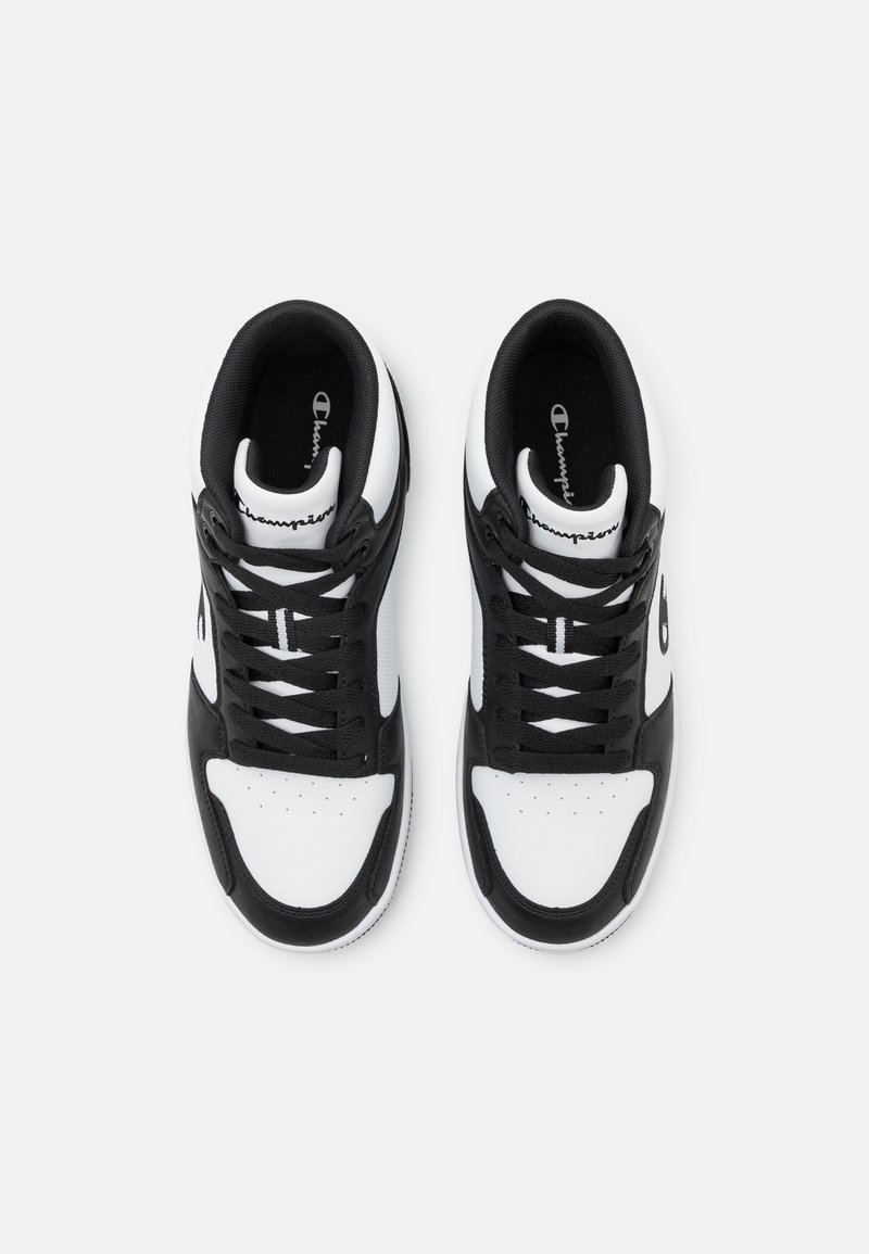 Schwarze und weiße Sport Sneakers mit einem glatten Lederobermaterial, runder Zehenpartie, Schnürdesign und Champion-Logo auf der Zunge.