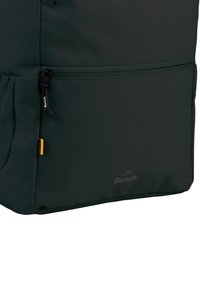 Mochila verde oscuro hecha de tela texturizada, con un bolsillo con cremallera, correas ajustables y un logo en la parte frontal.
