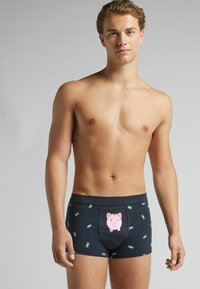 Navy Boxershorts mit einem Schweinmotiv auf der Vorderseite, verziert mit grünen Geldmustern, aus weichem Stoff und mit enger Passform.