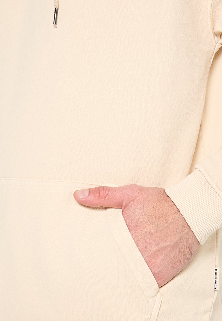 Felpa beige con tasca a marsupio, coulisse regolabile e polsini a coste. Tessuto morbido, design minimalista senza motivi.