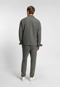Grå sweatshirt med krage, avslappnad passform och lång ärm, i kombination med matchande grå byxor. Har mjukt material och ribbade ärmslut.
