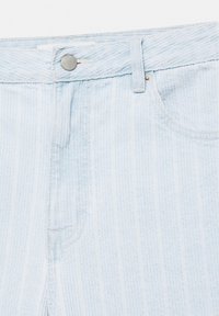 Jean en denim bleu clair avec fermeture par bouton métallique, passants pour ceinture et surpiqûres visibles sur la poche avant.