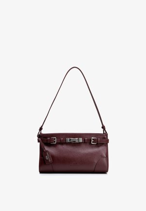 Bolso rectangular de cuero marrón oscuro con correa para el hombro, detalle de hebilla frontal y etiqueta de marca colgante sobre un fondo blanco.