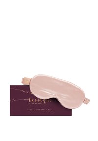 Mascherina da sonno in seta di un delicato rosa, con una texture liscia, e un logo decorativo dorato su una scatola marrone scuro con un motivo a stelle.