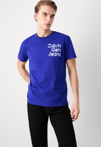 Calvin Klein Jeans STACKED EUPHORIC LOGO TEE - Camiseta estampada - sapphire blue