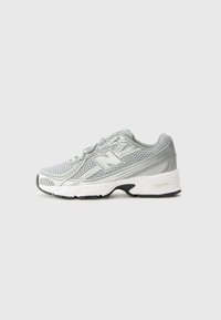 Zapatilla deportiva de color gris claro con parte superior de malla, acentos reflectantes y suela blanca acolchada. Presenta una suela exterior de goma negra y un sistema de cordones.