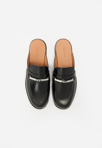 Scarpe slip-on in pelle nera con una finitura liscia, dotate di un accento in metallo argentato sulla parte anteriore e una soletta color beige.