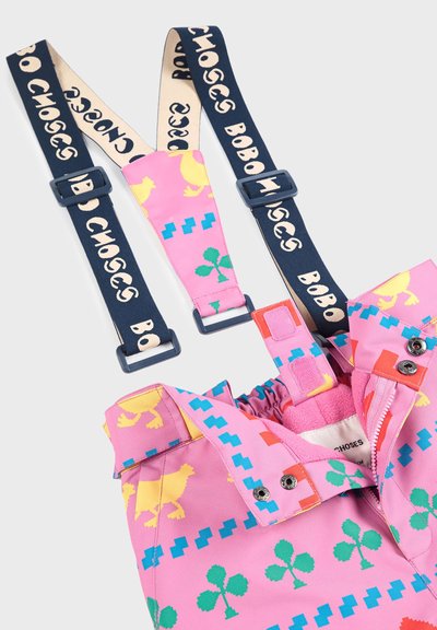 Lyserøde overalls med multicolore mønstre, herunder kyllinger, prikker og kløver. Har justerbare marineblå seler med "BOBO CHOSES"-tryk.