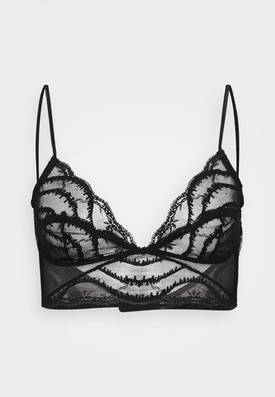 Black lace bralette with scalloped edges, sheer mesh fabric, intricate floral patterns, and thin adjustable shoulder straps.