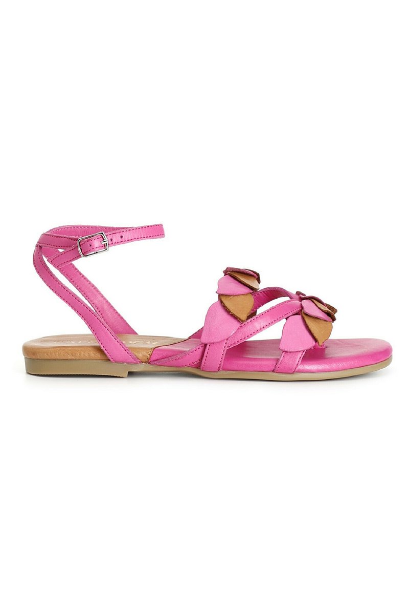 Sandalía de cuero rosa con suela plana, que presenta dos lazos en un tono más oscuro y una correa ajustable en el tobillo. Textura suave y diseño simple.