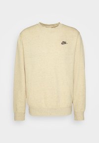 Sweatshirt beige fabriqué en tissu texturé avec des flocons. Présente un col rond et des manches longues, avec un petit logo Nike noir sur la poitrine.