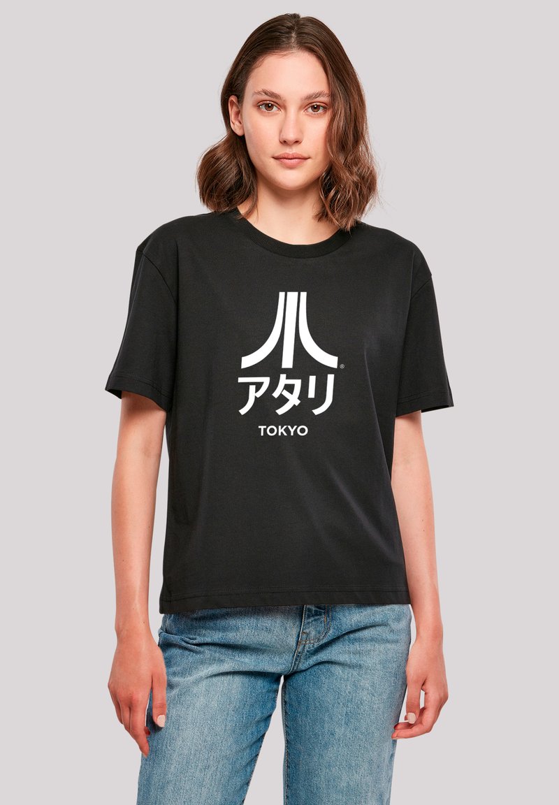 Schwarzes T-Shirt aus Baumwolle, mit einem weißen Atari-Logo und japanischem Text "TOKYO." Lockere Passform mit kurzen Ärmeln.