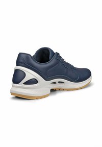 Sneaker in pelle di colore blu scuro con suola bianca e in gomma color caramello. Presenta un collarino imbottito, chiusura con lacci e fori di ventilazione sui lati.