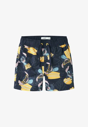 Shorts de bain pour enfants bleu marine avec taille élastique, motifs répétitifs de planches de surf jaunes et personnage de dessin animé portant des lunettes de soleil.