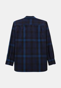 Chemise à carreaux dans des tons de bleu foncé et noir, avec des manches longues, des poignets boutonnés et un détail de patte de bouton au dos. Fabriquée en tissu lisse.