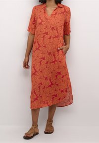 Rode jurk met korte mouwen, voorzien van een bladenpatroon in oranje. Inclusief een kraag en zijzakken, gemaakt van lichtgewicht stof.