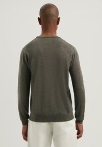 Olijf groene gebreide trui met lange mouwen, een ronde hals en ribgebreide manchetten en zoom. Gladde textuur en minimalistisch ontwerp.