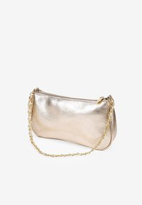 Bolso de mano metálico dorado con textura suave, forma alargada, cierre de cremallera y correa de cadena dorada.