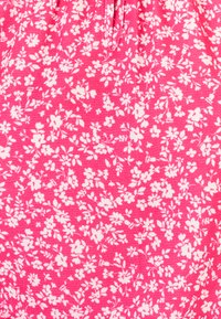 Tessuto floreale rosa con piccoli fiori e foglie bianche sparsi. Materiale leggero e texturizzato con una finitura morbida.
