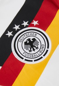 Broderad logotyp för Tyska fotbollsförbundet med fyra vita stjärnor på svart, rött och gult randigt tyg.