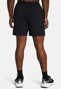 Schwarze Sportshorts mit elastischem Bund, Seitentaschen und einer Gesäßtasche. Glattes Material und taillierte Passform.