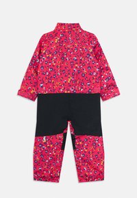 Jumpsuit bicolore per bambini con stampa floreale rosa, viola e gialla sulle maniche e sulle gambe inferiori, parte centrale nera e maniche lunghe.