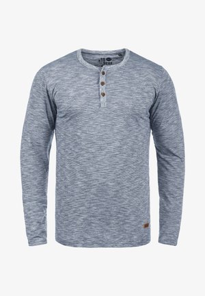 Langärmliges graues Henley-Shirt aus strukturiertem Gewebe, mit drei Holzknöpfen am Hals und einem kleinen Logo-Patch am Saum.