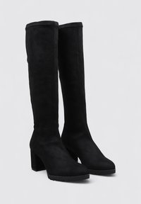 Botas de ante negras hasta la rodilla con un tacón grueso, textura suave y punta afilada. Diseño minimalista sin herrajes o patrones visibles.