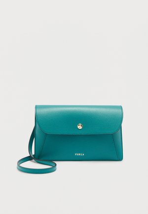 Τσαντάκι Furla από δέρμα σε πράσινο-μπλε χρώμα, με καπάκι, κλείσιμο με χρυσό κουμπί και λεπτό λουράκι ώμου, πάνω σε απλό φόντο.