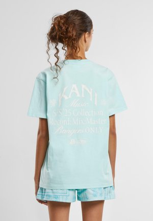 Himmelblaues Baumwoll-T-Shirt mit weißem Aufdruck auf der Rückseite, der Text und Logo enthält. Kurze Ärmel, lässige Passform und Rundhalsausschnitt.