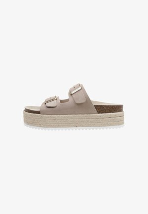 Sandalias de plataforma beige con dos tiras ajustables, hechas de material suave, con una suela de yute trenzado y una plantilla de corcho texturizada.