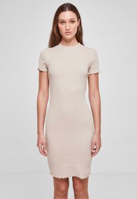 Robe beige côtelée à manches courtes et ourlet festonné. Coupe slim, design minimal, texture douce, adaptée aux occasions décontractées.