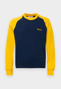 Mørkeblå hettegenser med gule raglanermer, gul krage, mansjetter og "Fiorucci" logo brodert på brystet.