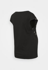 Top preto de manga curta com decote redondo. Tecido suave e detalhes laterais com pequenas aplicações metálicas. Ajuste casual.