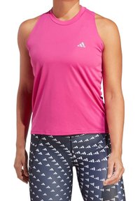 Top de entrenamiento sin mangas, ajustado, en color rosa, con cuello redondo y un pequeño logo reflectante, combinado con leggings negros estampados que presentan un diseño geométrico.