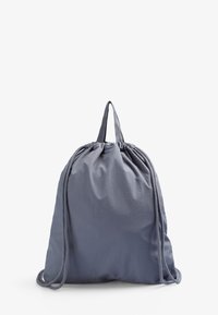 Sæk med snoretræk i lys grå stof, der har en samlet top og dobbelte snorestropper. Glat tekstur med et enkelt design.